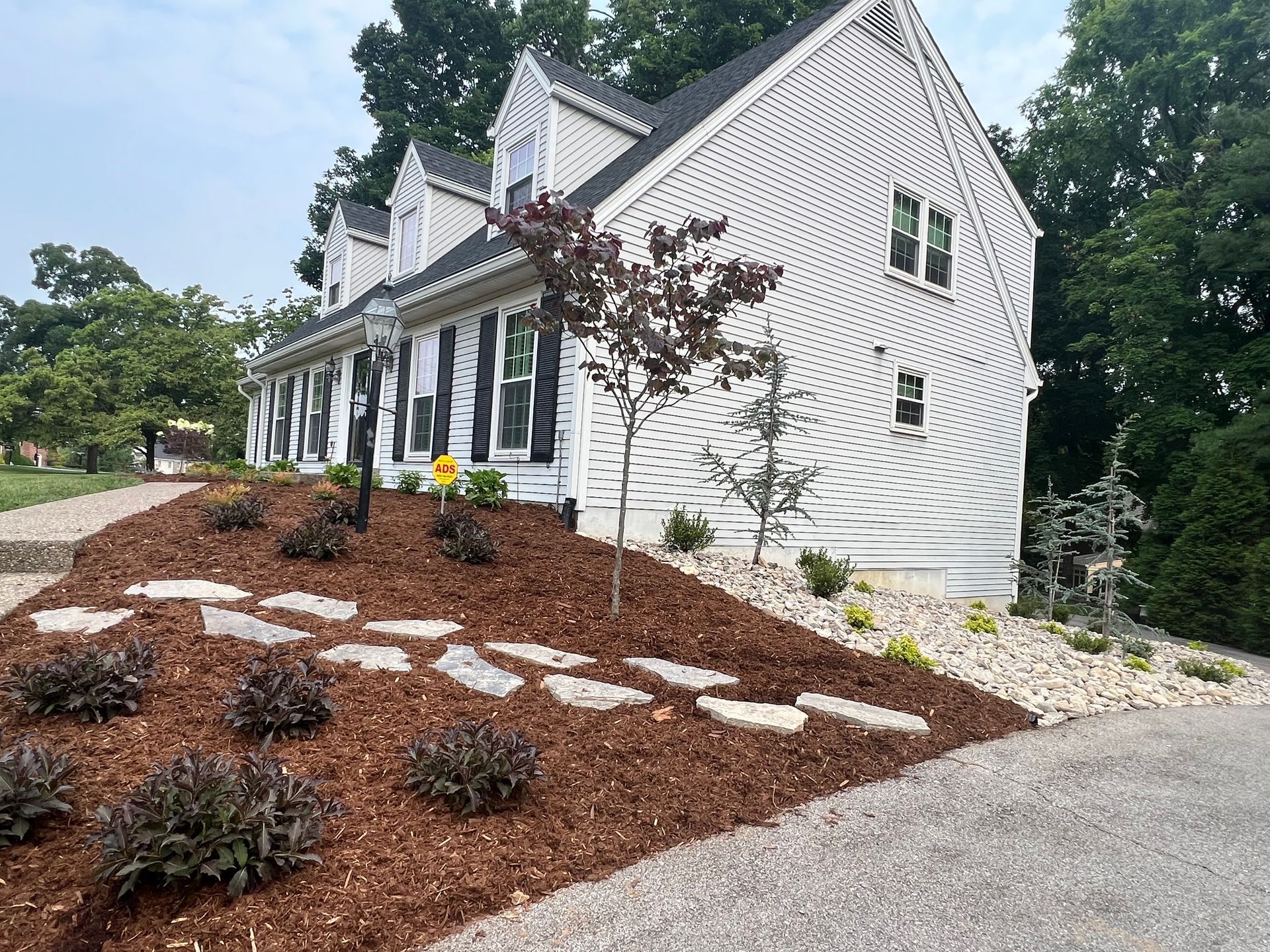 A White House is Sitting on Top of a Hill next to a Driveway – Louisville, KY – Wayne's Lawn Service