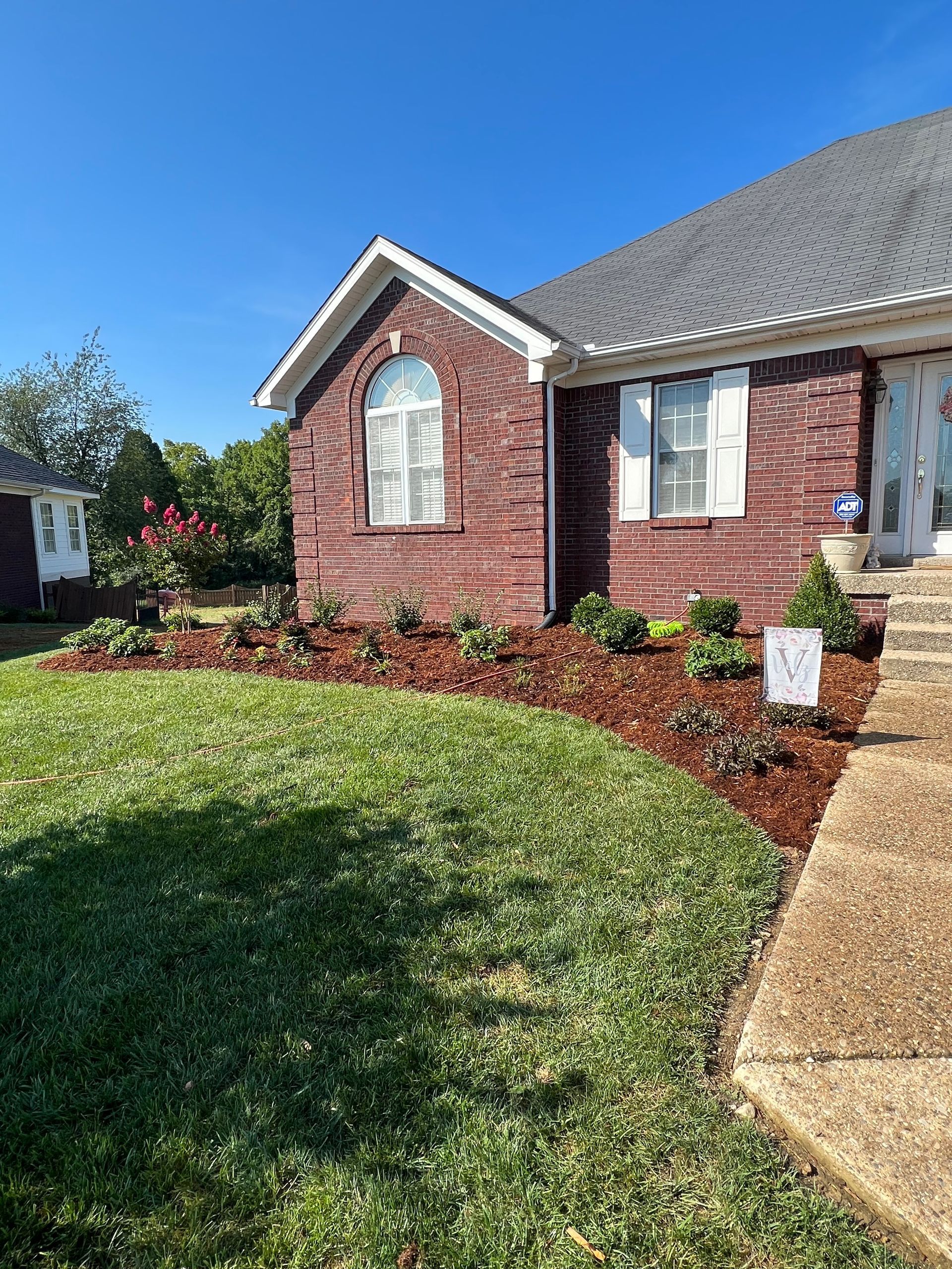 A Brick House with a Lush Green Lawn in Front of it – Louisville, KY – Wayne's Lawn Service