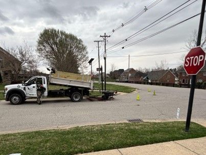 A dump truck is parked on the side of the road next to a stop sign.