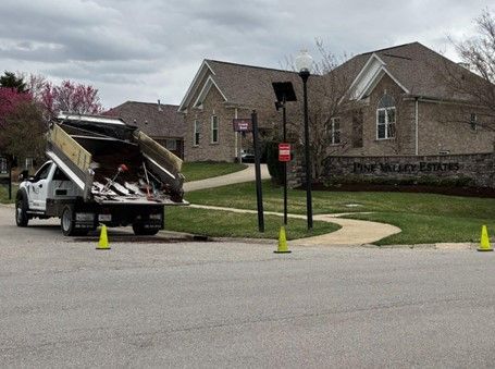 A tow truck is parked on the side of the road in front of a house.