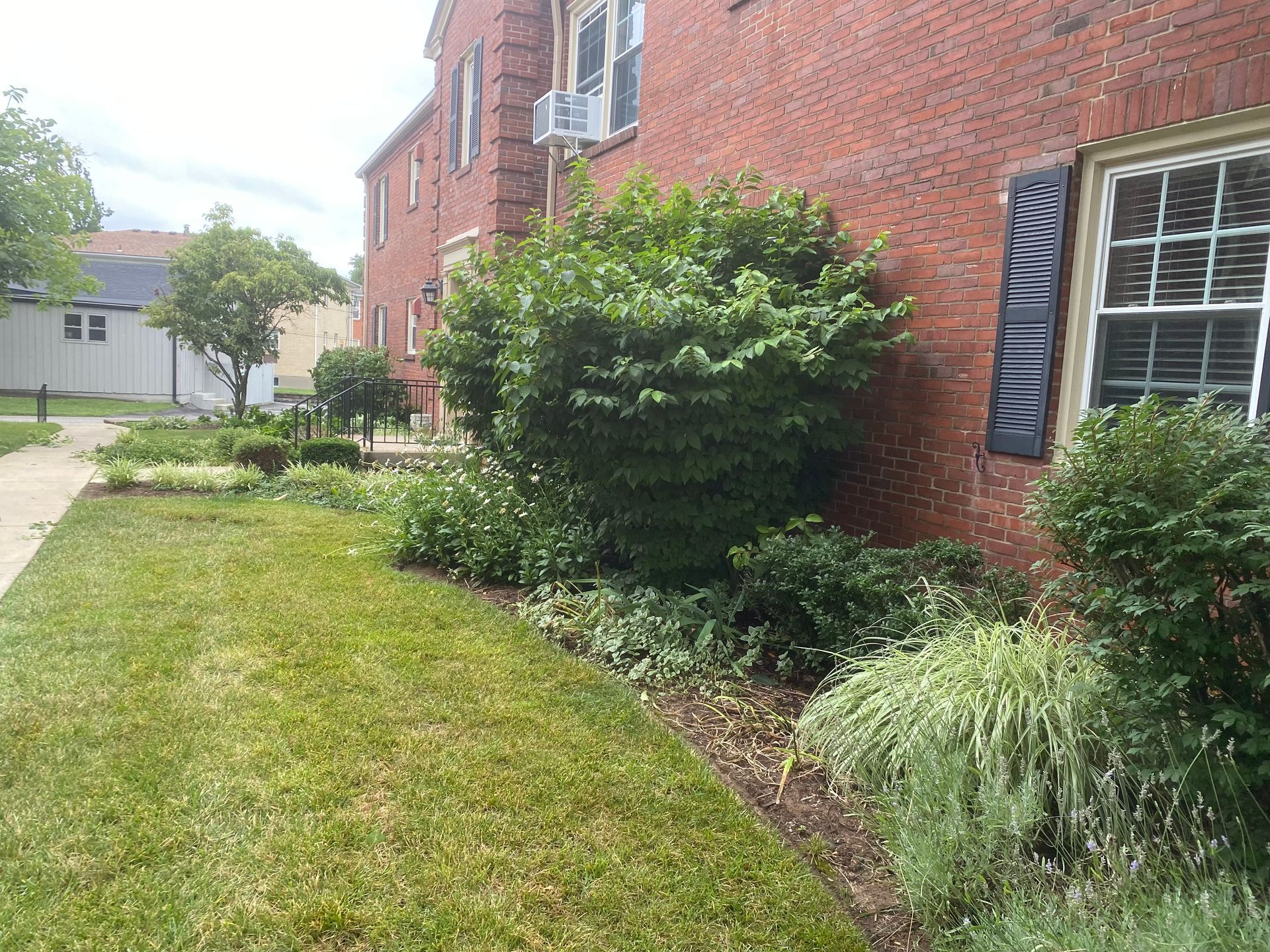 A brick building with a lush green lawn in front of it.