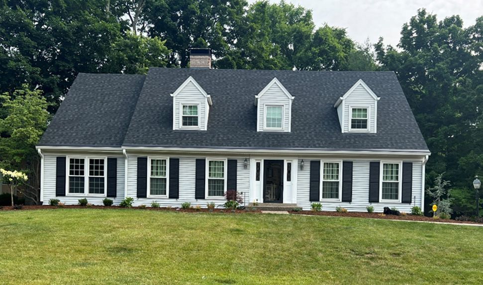 A large white house with a black roof and black shutters