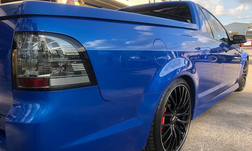 A blue pickup truck is parked on the side of the road.