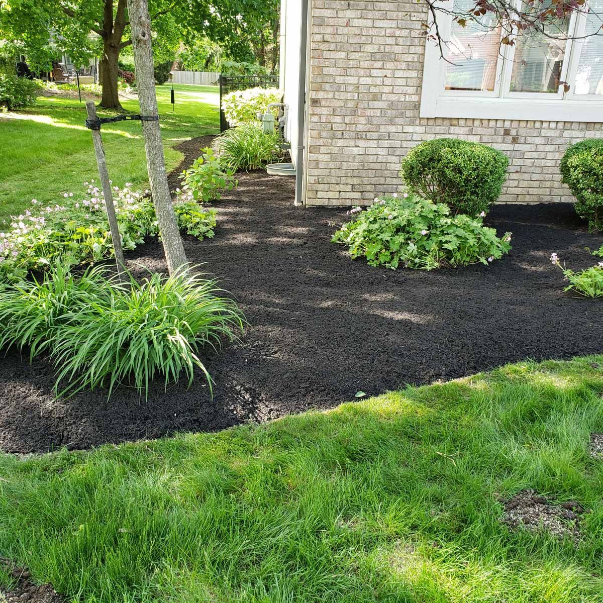 A brick house with a lush green lawn in front of it.