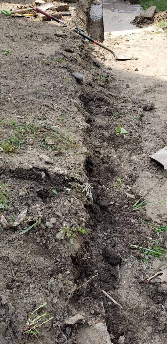 A person is digging a hole in the ground with a shovel.