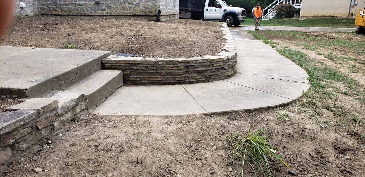 A concrete walkway is being built in front of a house.