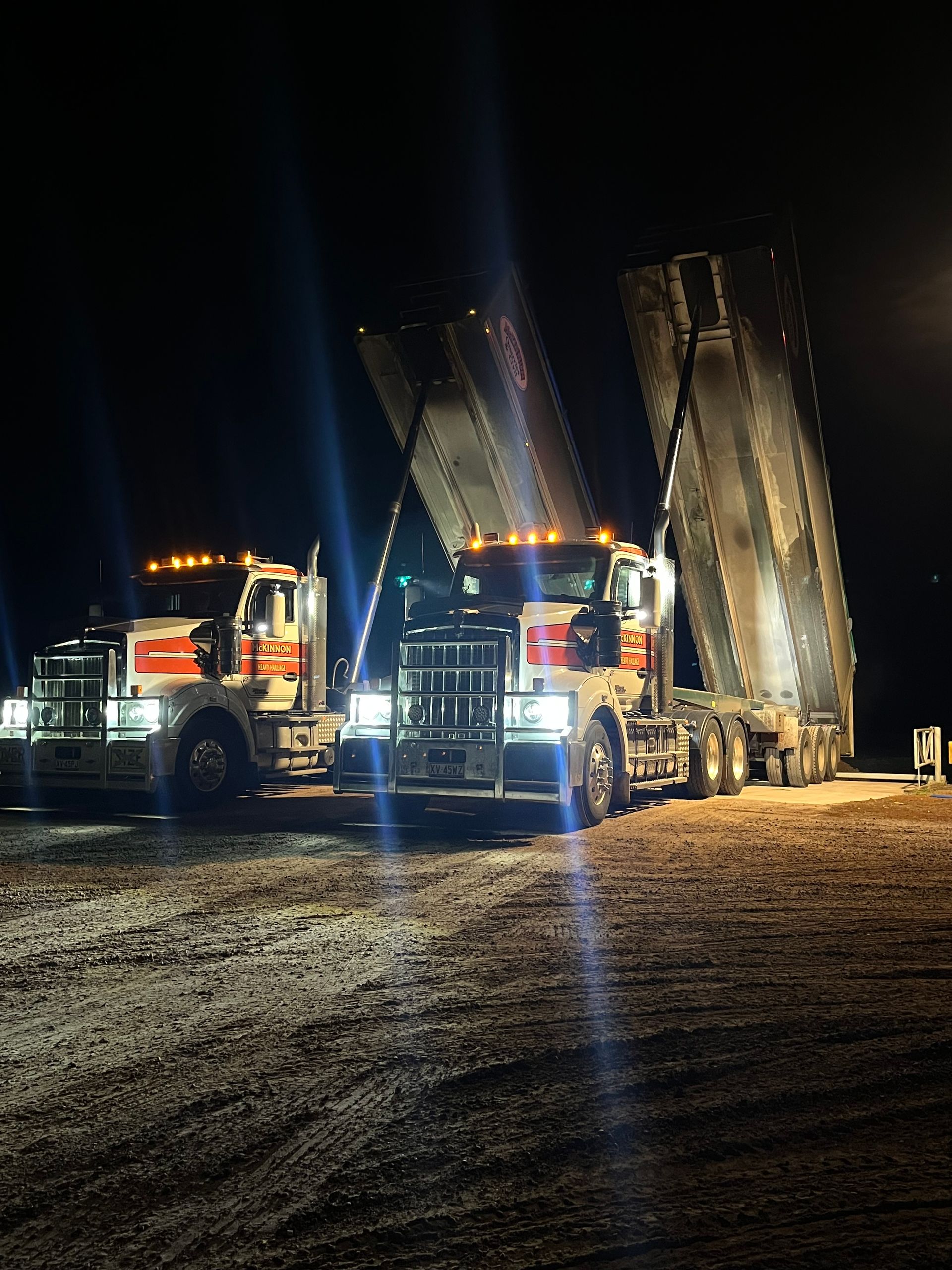 A Semi Truck Is Driving Down A Dirt Road Next To A Field – Warrnambool, VIC - McKinnon Quarries & Civil