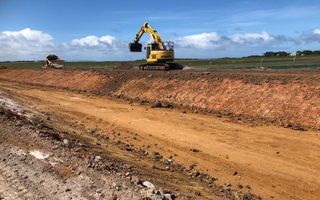 A Yellow Excavator Is Driving Down A Dirt Road – Warrnambool, VIC - McKinnon Quarries & Civil