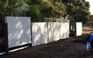 A Blue Wheelbarrow Is Parked In Front Of A White Fence – Warrnambool, VIC - McKinnon Quarries & Civil