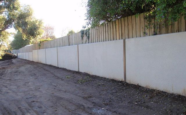 A Concrete Wall With A Wooden Fence Behind – Warrnambool, VIC - McKinnon Quarries & Civil