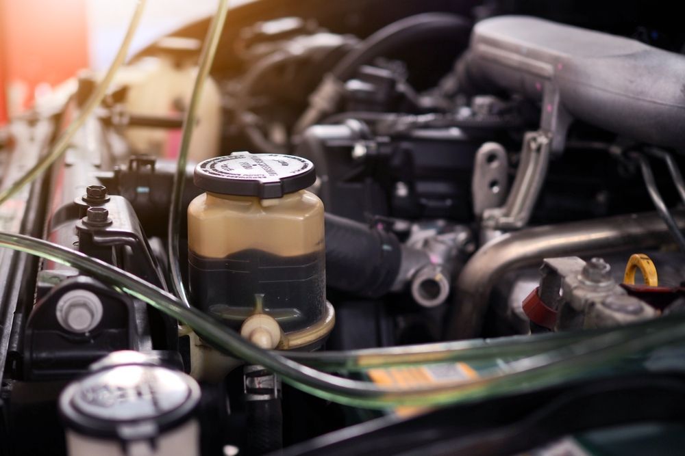Car engine bay, power steering fluid reservoir visible, other parts, tubes — Prime Mobile Mechanics in Varsity Lakes, QLD