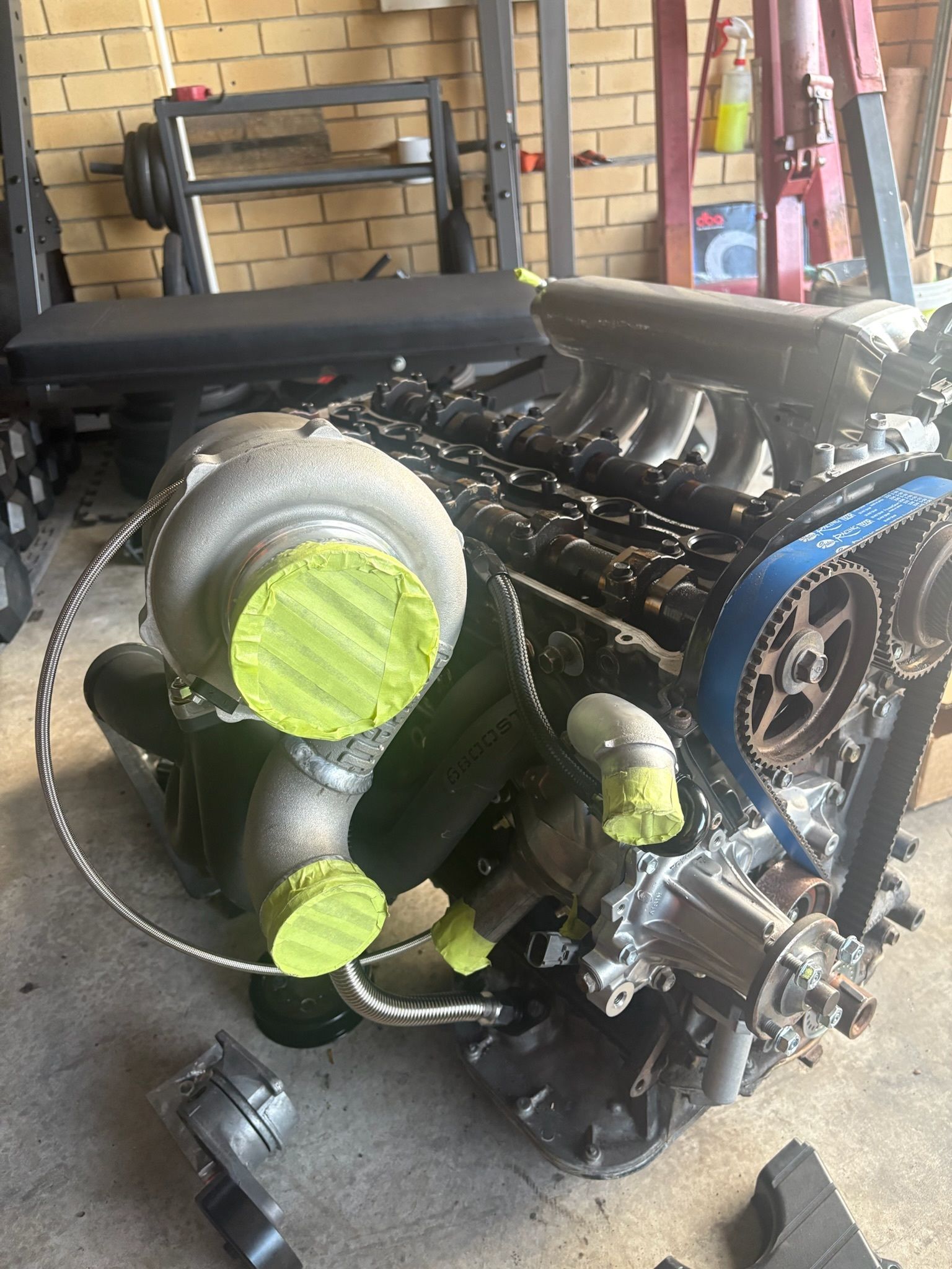 An Engine With a Large Turbocharger, Painted Yellow, in a Garage Setting — Prime Mobile Mechanics in Robina, QLD