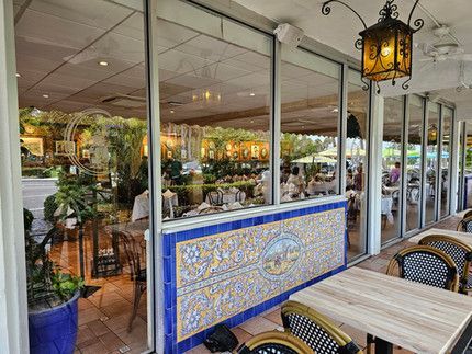 A restaurant with tables and chairs and a lantern hanging from the ceiling.