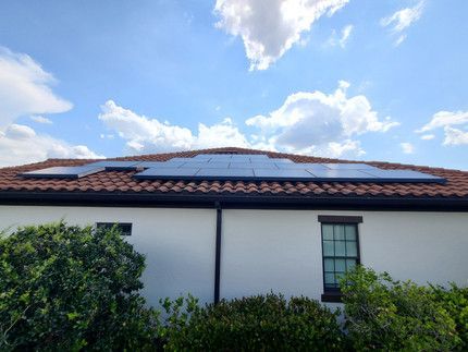 A white house with solar panels on the roof.