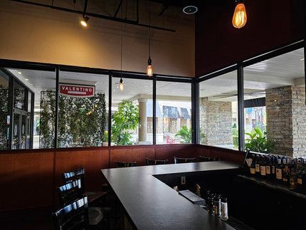 A restaurant with a bar and a lot of windows.