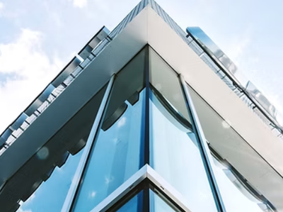 Looking up at the corner of a building with a balcony