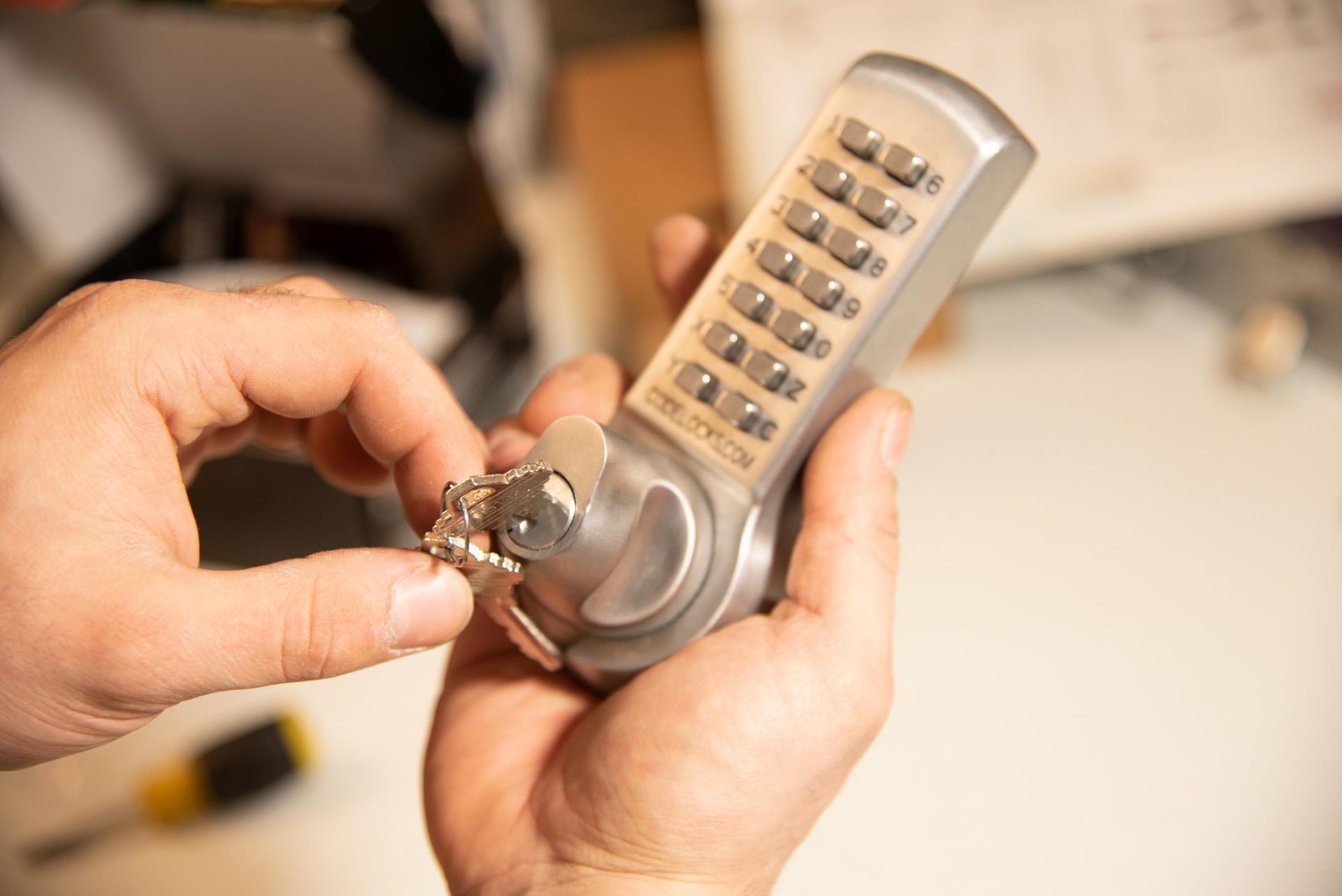 Hands holding a combination lock with keys.