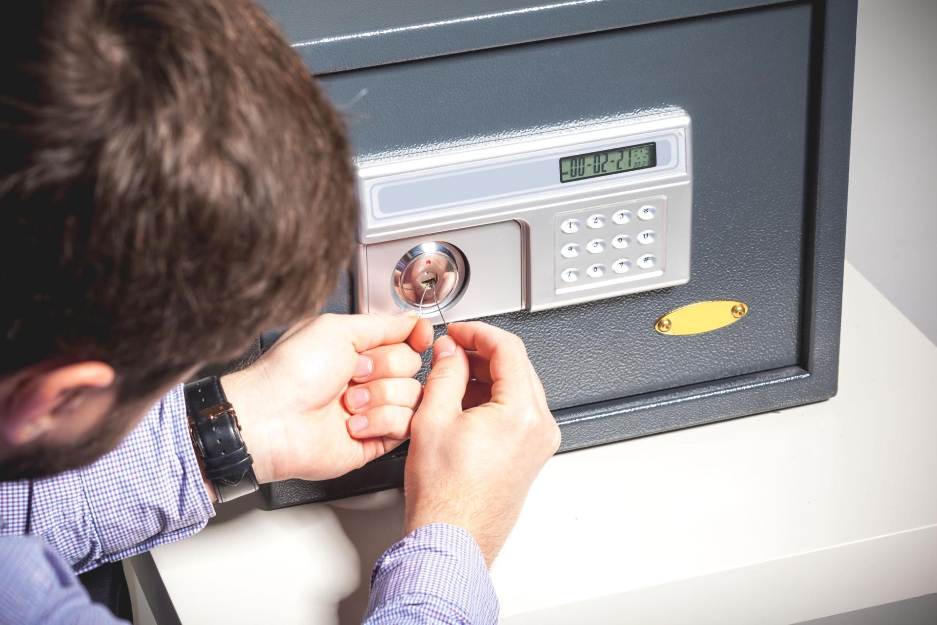 Person using a tool to try and open a digital safe.