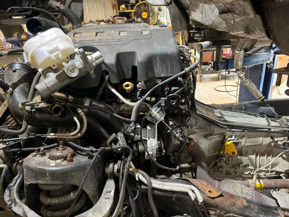 Engine and components of a vehicle, partially disassembled in a workshop.