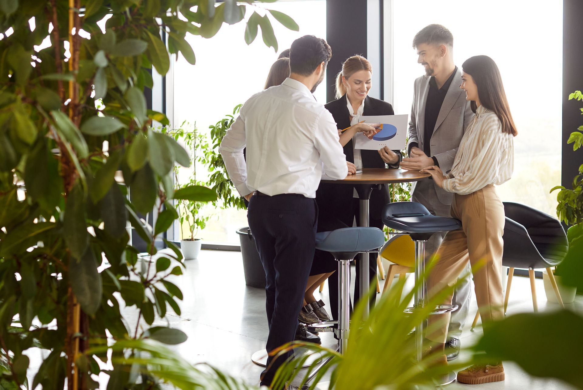 A group of people are standing around a table in an office.