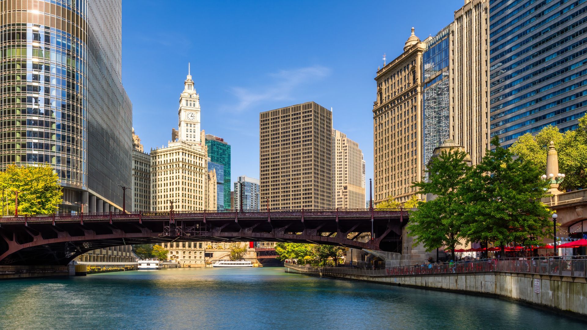 Chicago River with buildings, bridge, and clear blue sky.