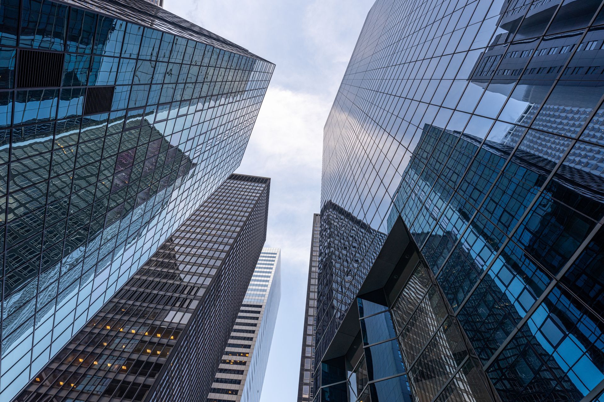 Skyscrapers in a city, viewed from a low angle, with a cloudy sky.