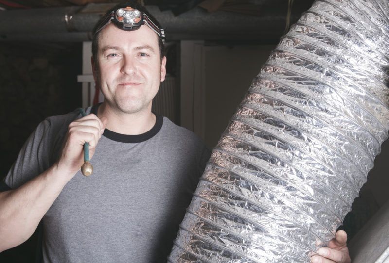 Man with headlamp holding silver flexible ductwork Man with headlamp holding silver flexible ductwork