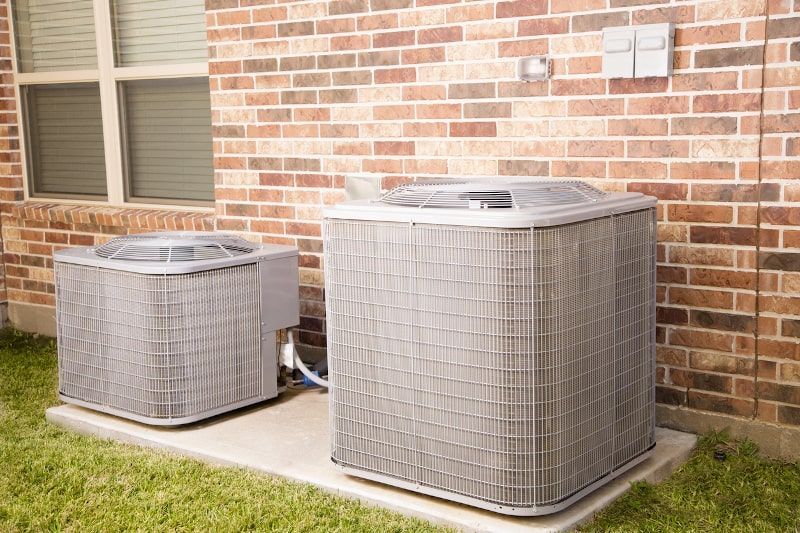 Two air conditioning units on a concrete pad