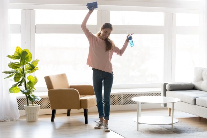 Woman celebrates cleaning in bright living room
