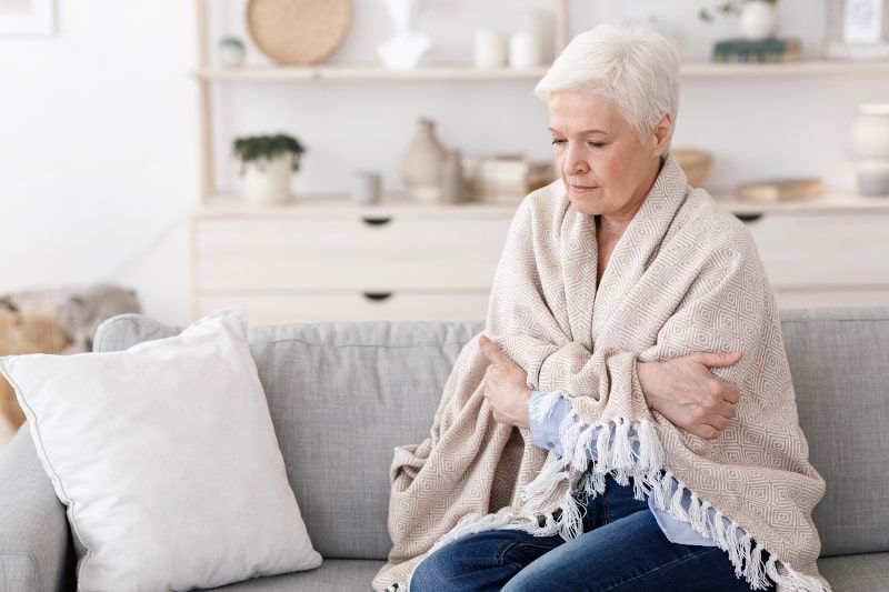 Woman wrapped in blanket on a couch
