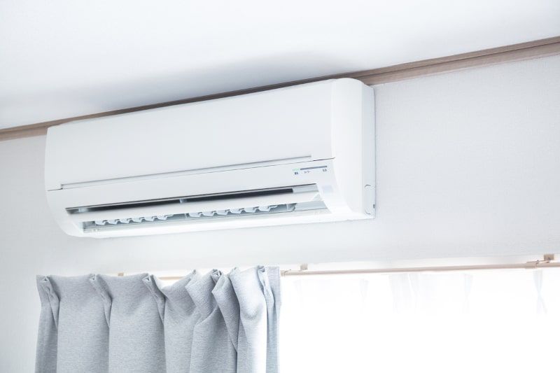 White air conditioner unit mounted on a white wall