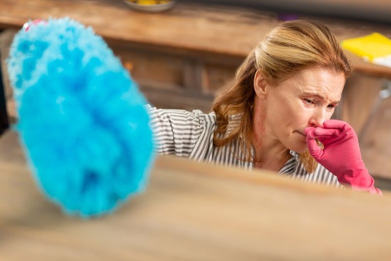 Woman cleaning a dusty room