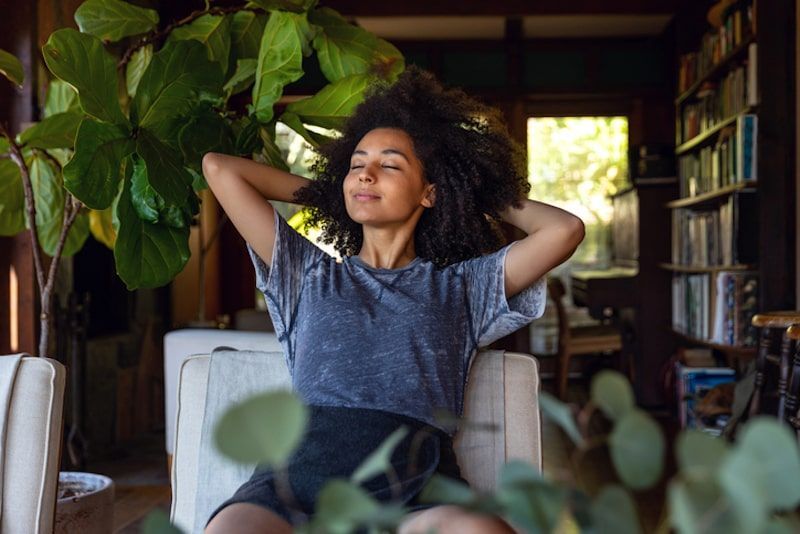 Woman relaxing in chair with hands behind head