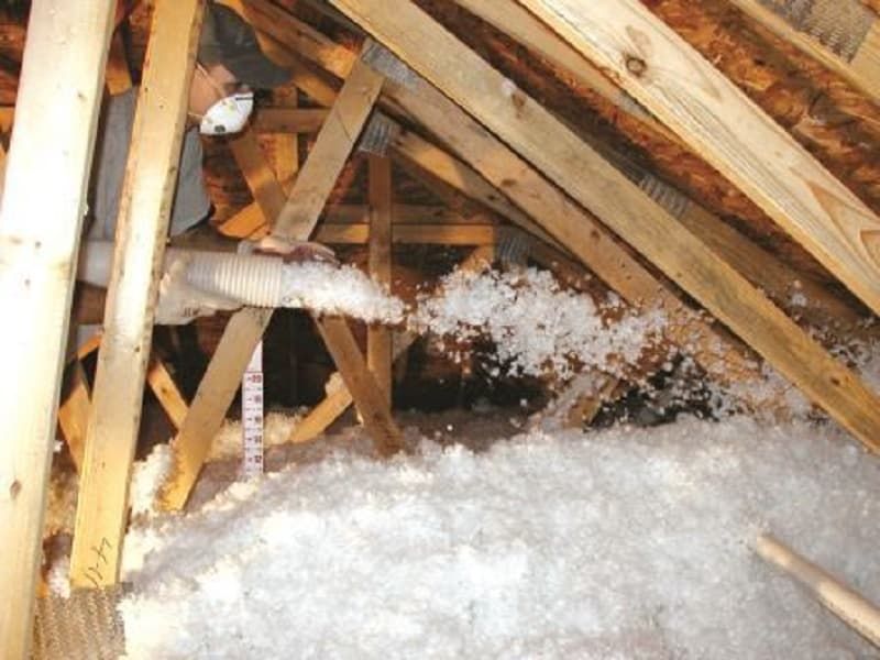 Attic with insulation being blown in through a hose