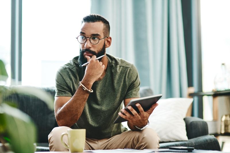 Man with glasses holding tablet and pen