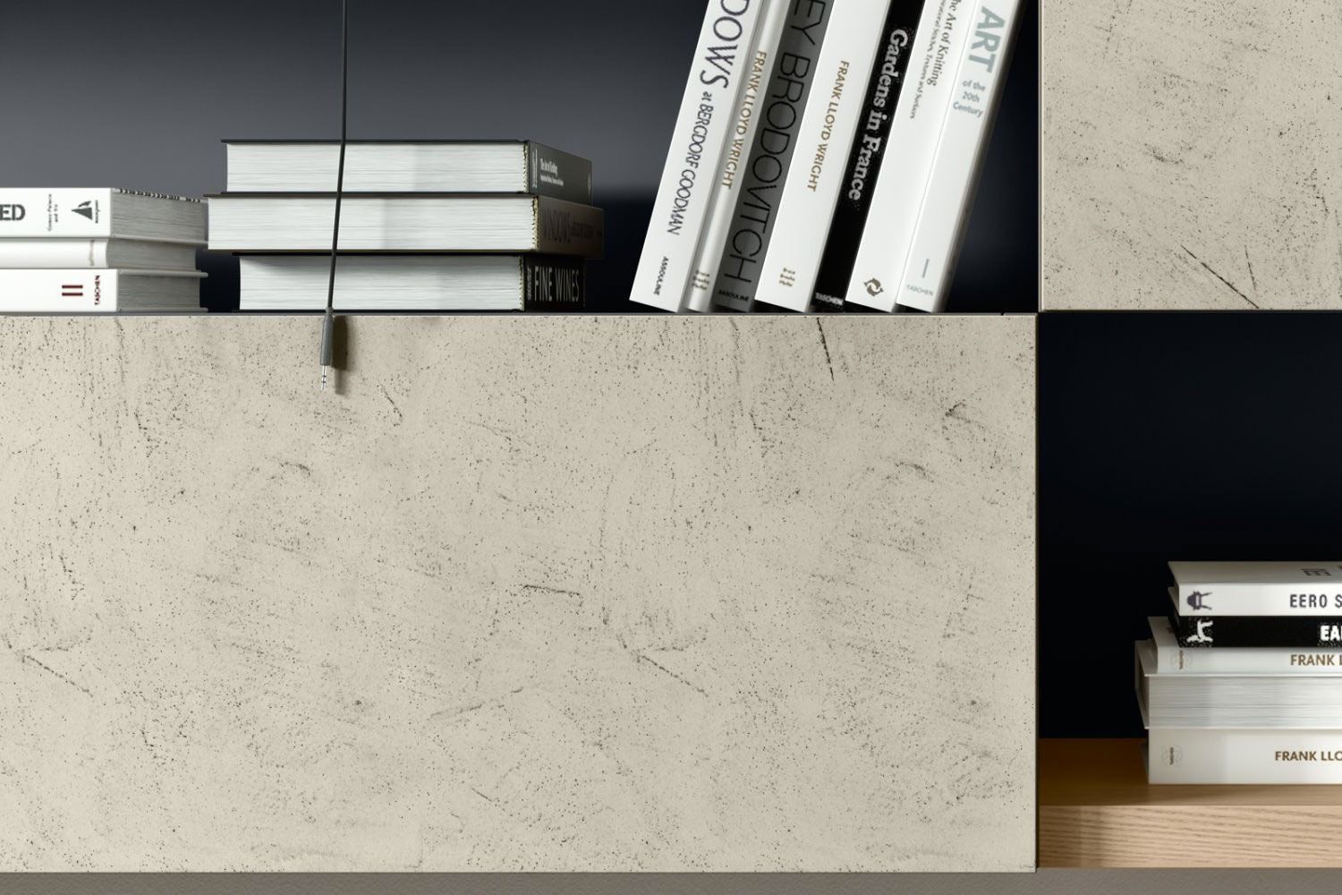 Scaffalatura moderna con libri e oggetti impilati su un mobile in cemento chiaro.