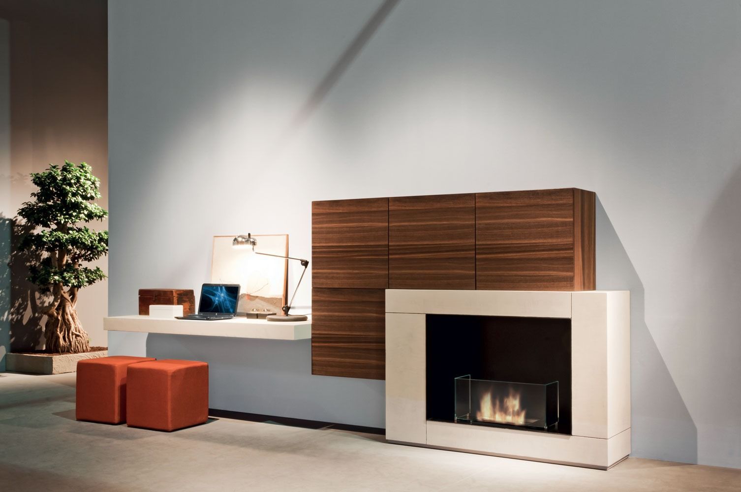 Soggiorno moderno con camino bianco, mobile a muro in legno e pouf arancione su un pavimento grigio pulito.