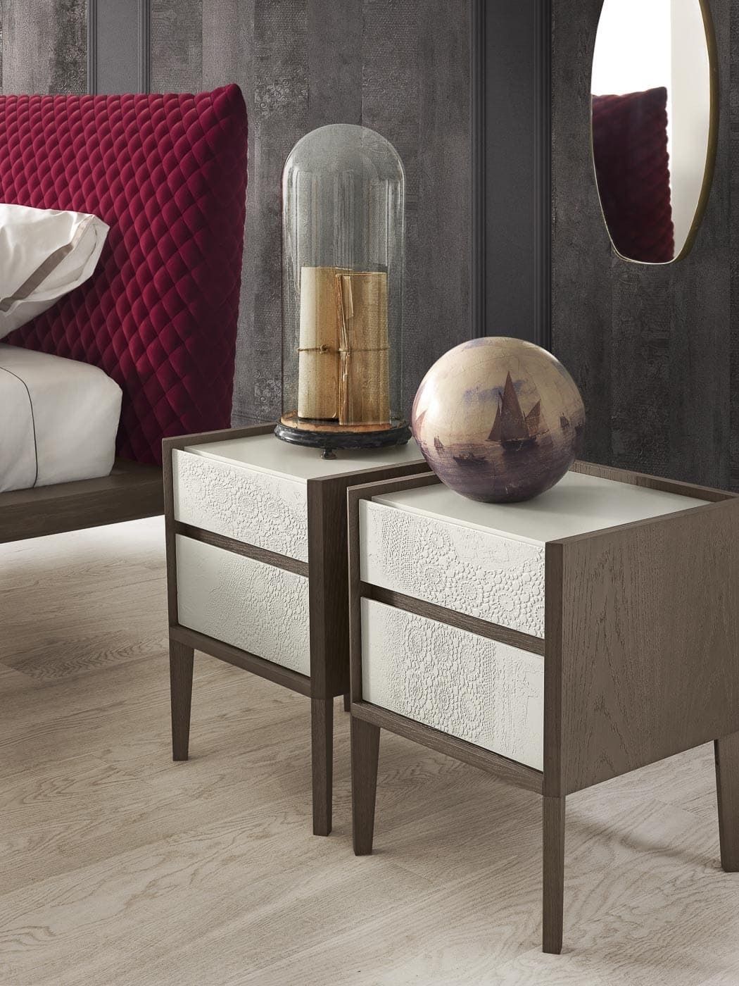 Due comodini moderni con cassetti bianchi, struttura in legno scuro e vasi decorativi in ​​una camera da letto