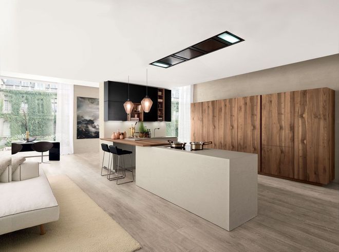 Cucina e zona pranzo moderne e minimaliste con isola bianca, mobili in legno e ampie finestre.