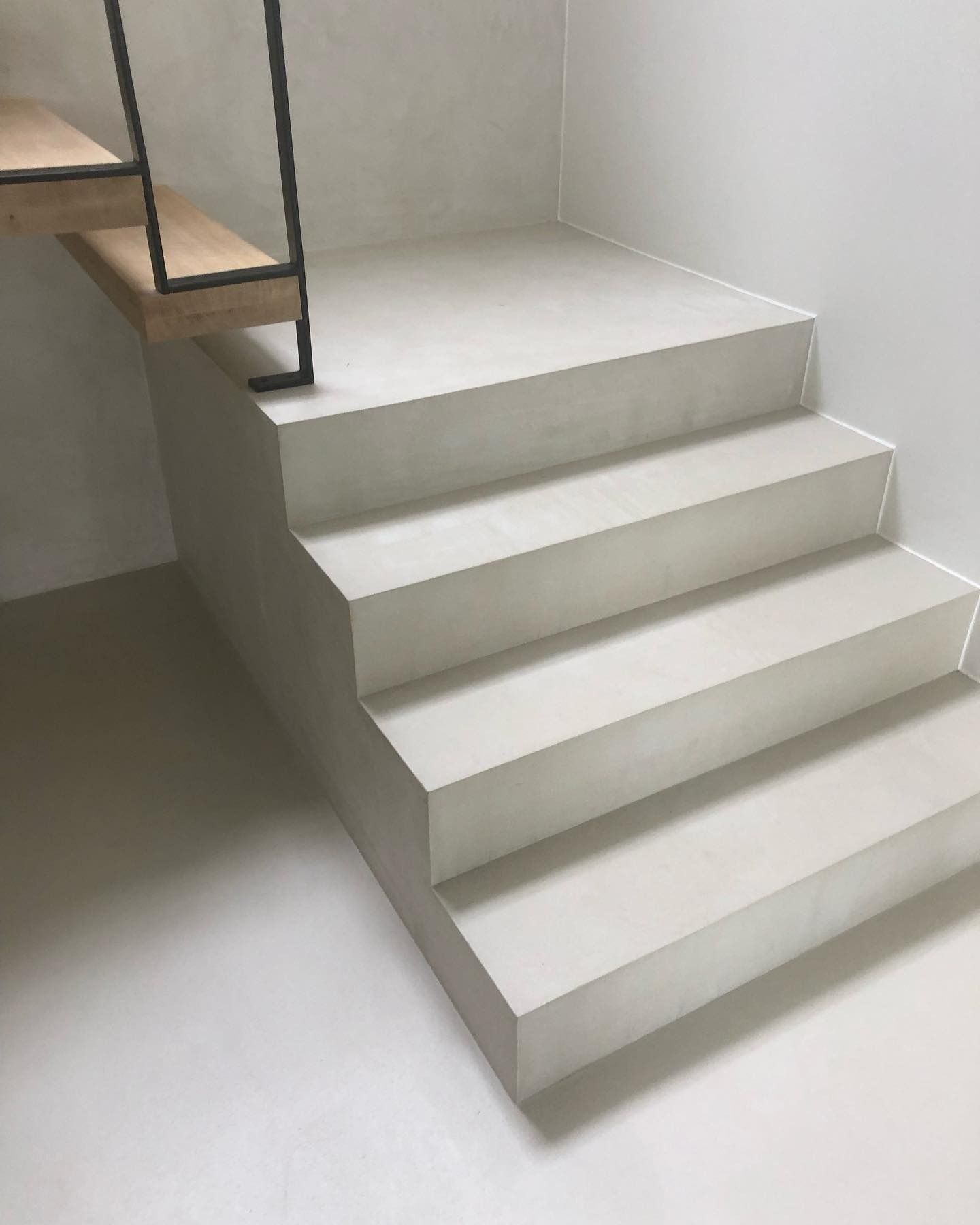 Scala interna bianca con tre gradini e corrimano in metallo nero.