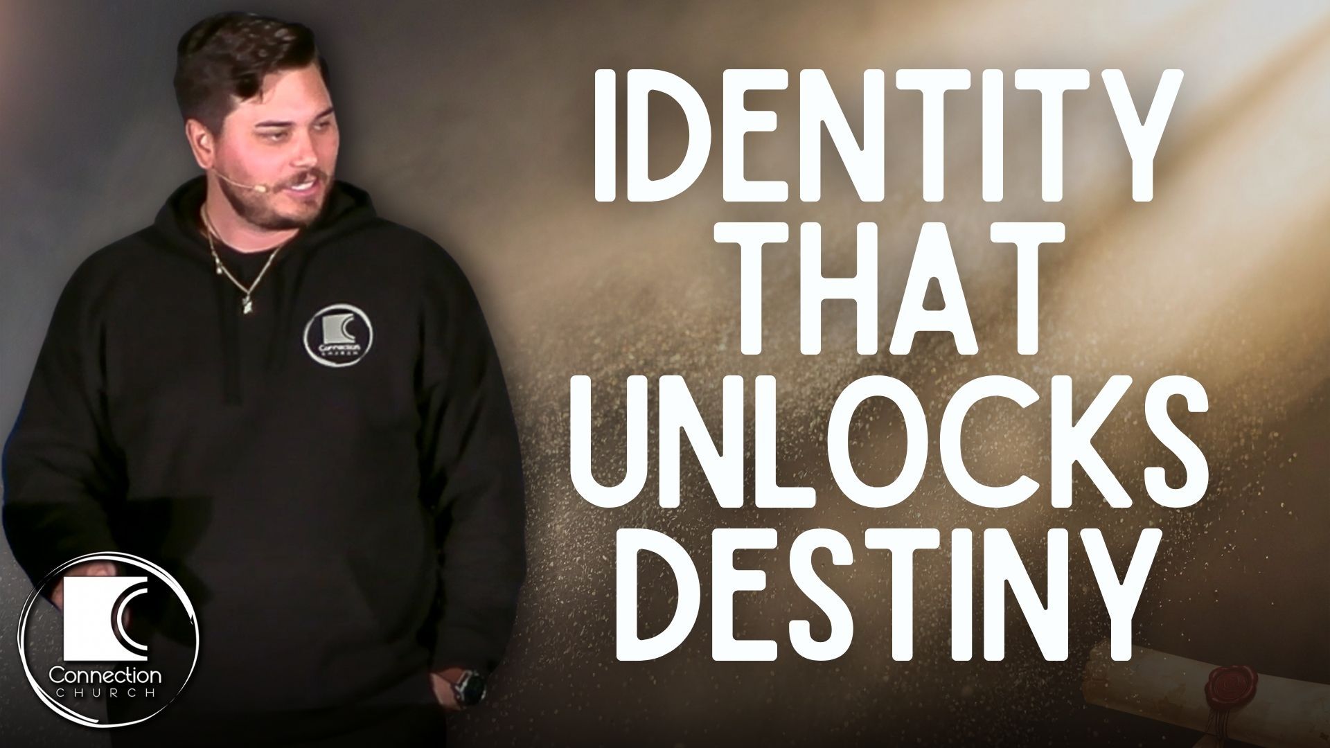 Man in black hoodie next to text 