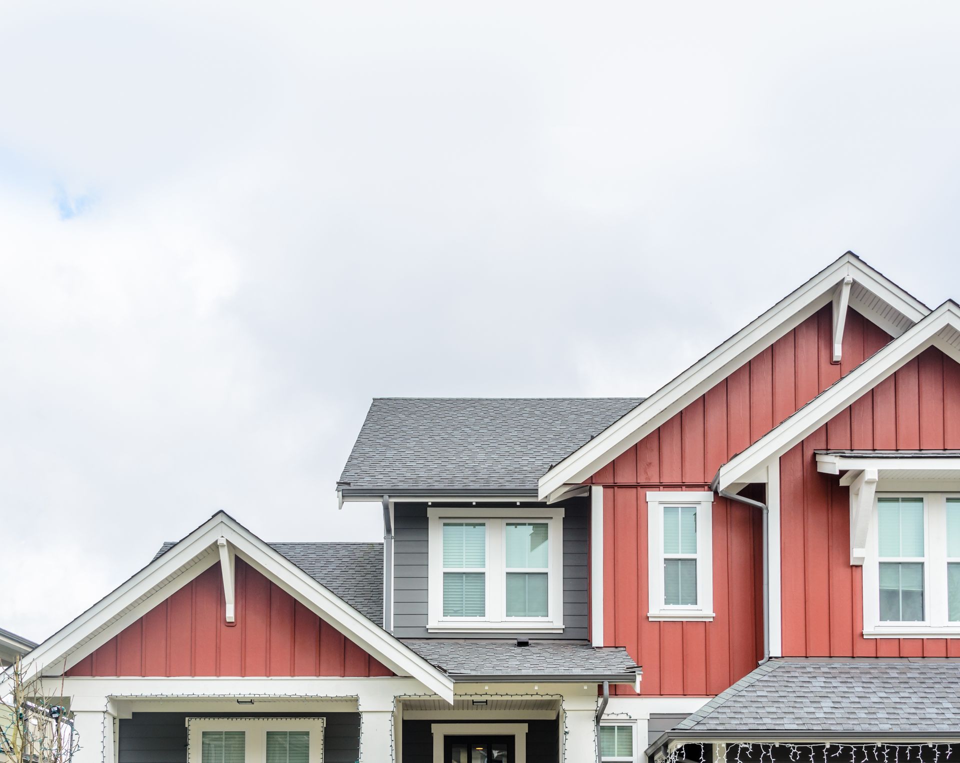 Red and gray townhouses with white trim against a cloudy sky.