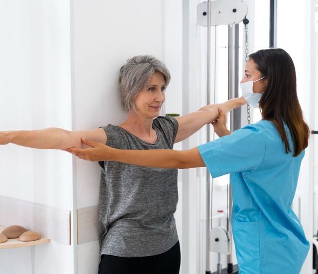 Fisioterapeuta midiendo el rango de movimiento del brazo de un paciente en una clínica.
