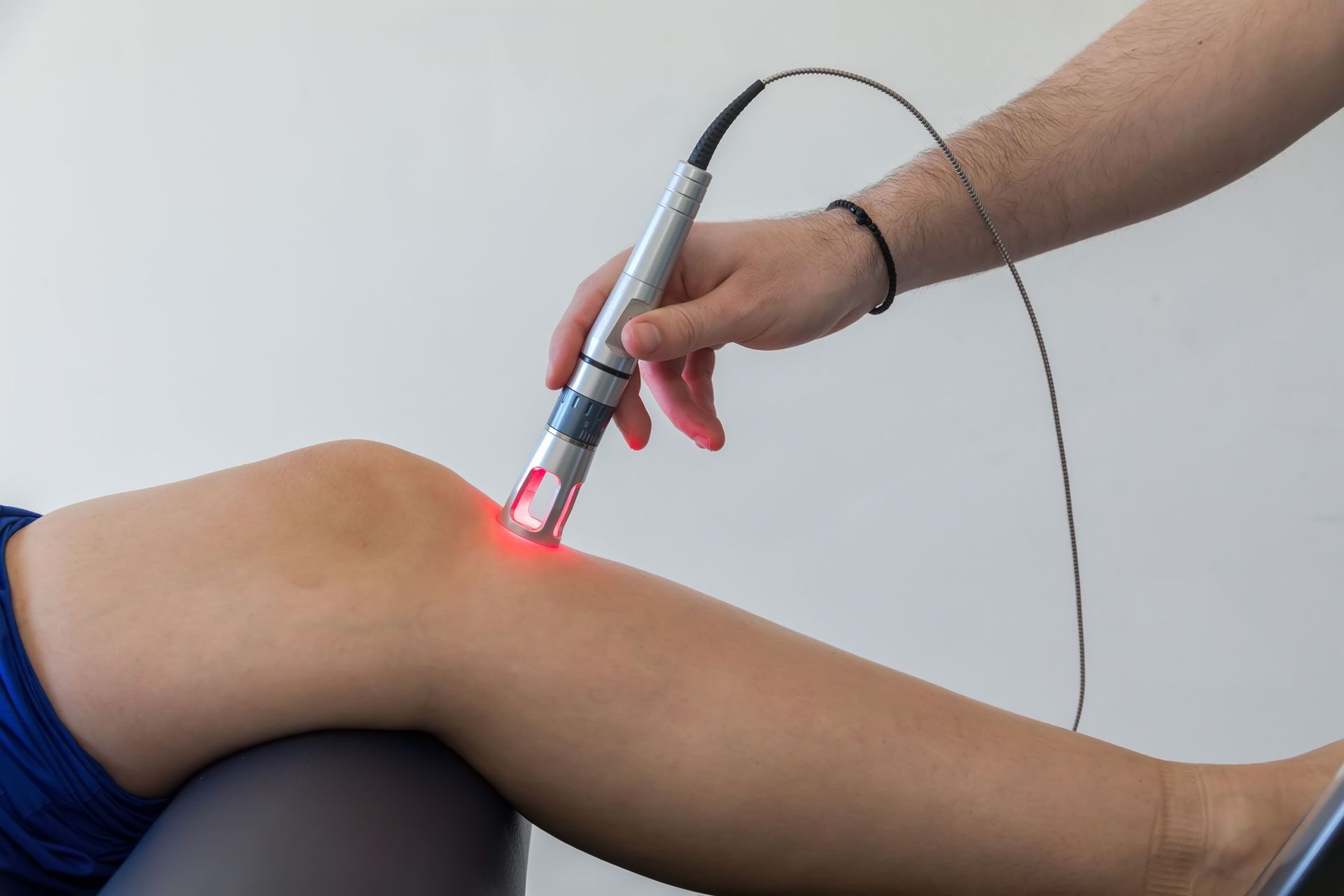 a man is sitting at a desk with his back in pain .
