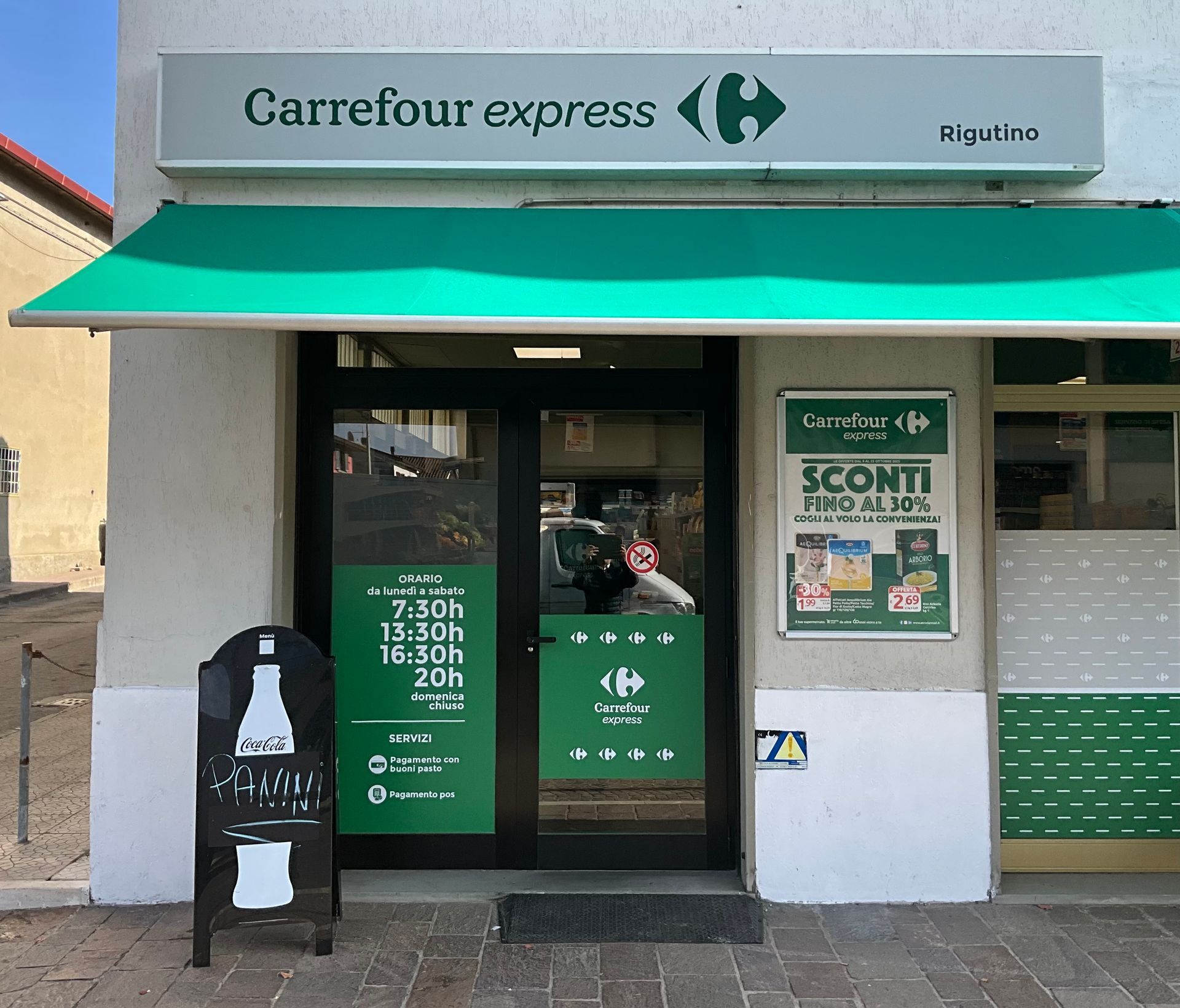 vertrina esterna del Carrefour Express Rigutino con pubblicità delle offerte e insegna