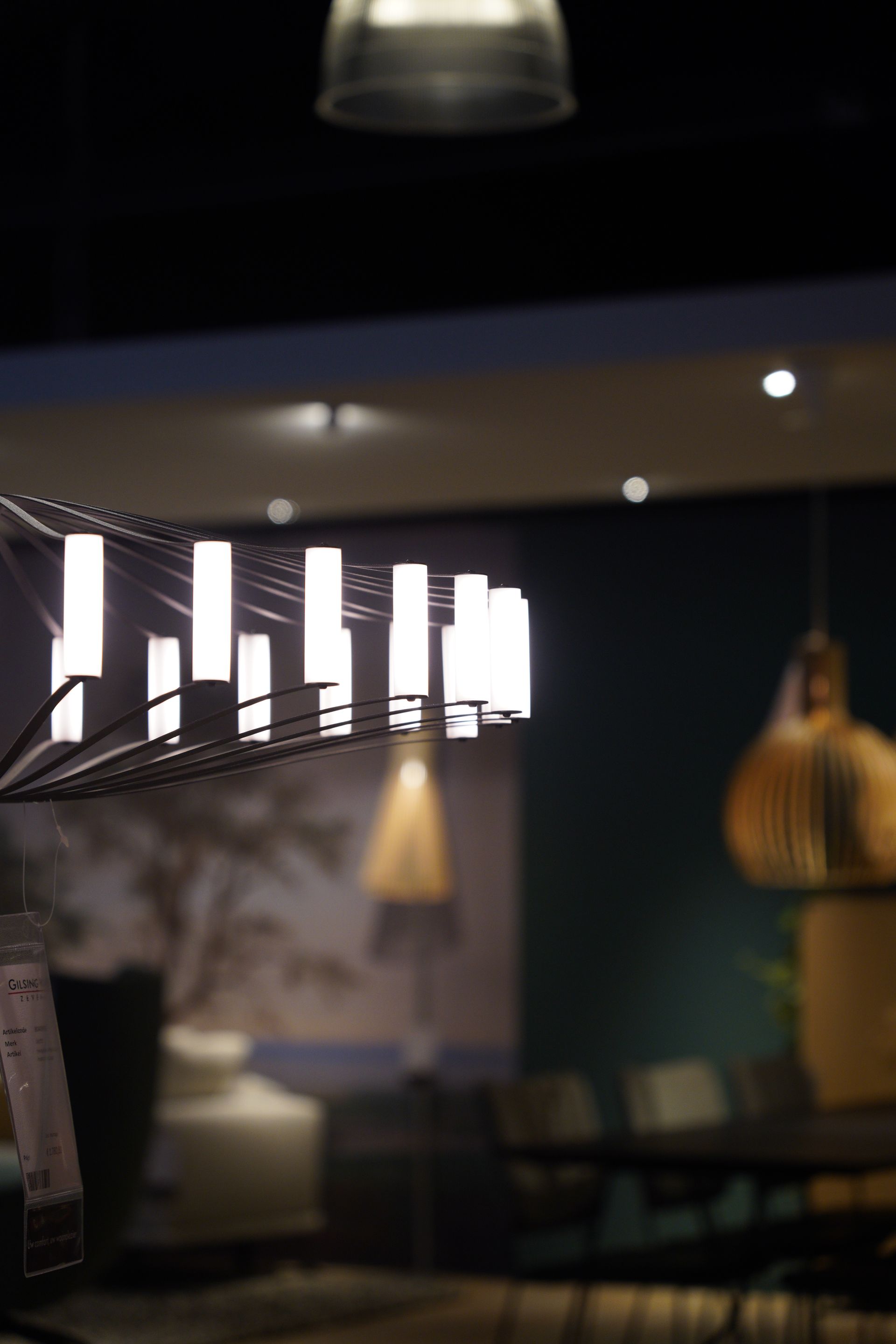 Modern interior with hanging lights and a partially visible dining area.