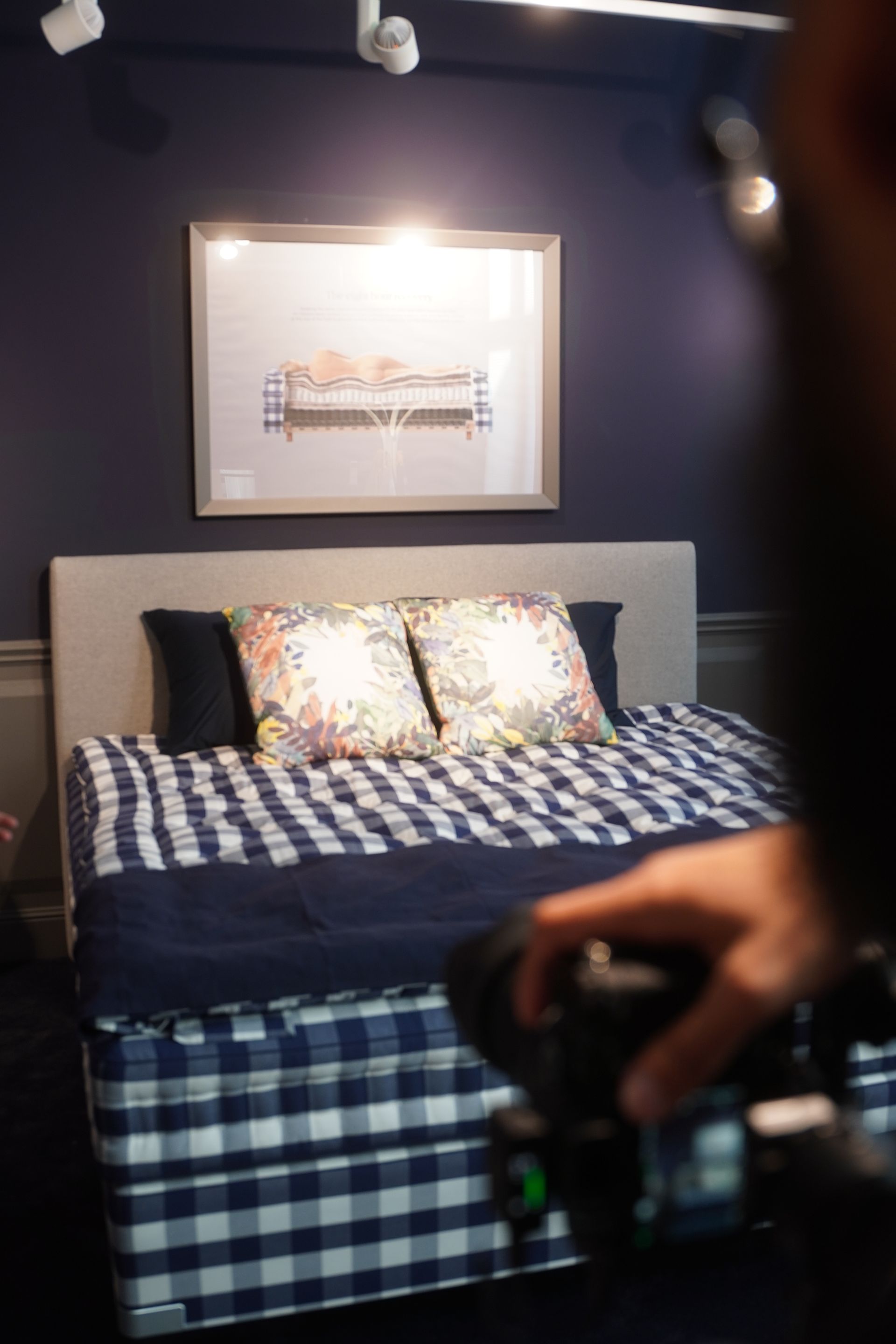 A person is taking a picture of a bed in a bedroom