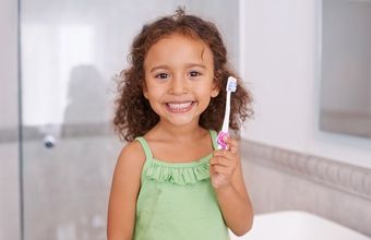 young girl holding toothbrush