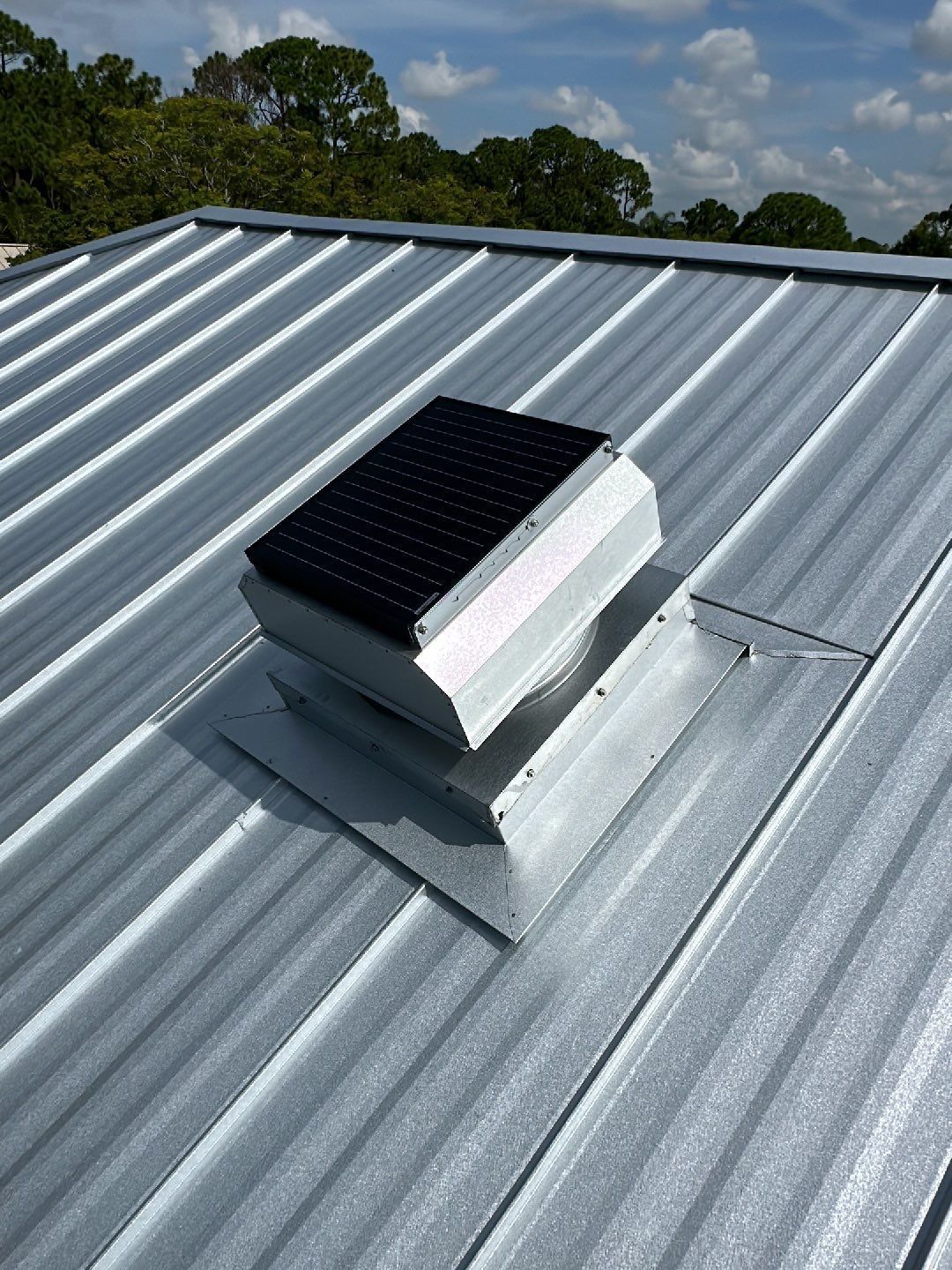 A metal roof with a solar panel on top of it.