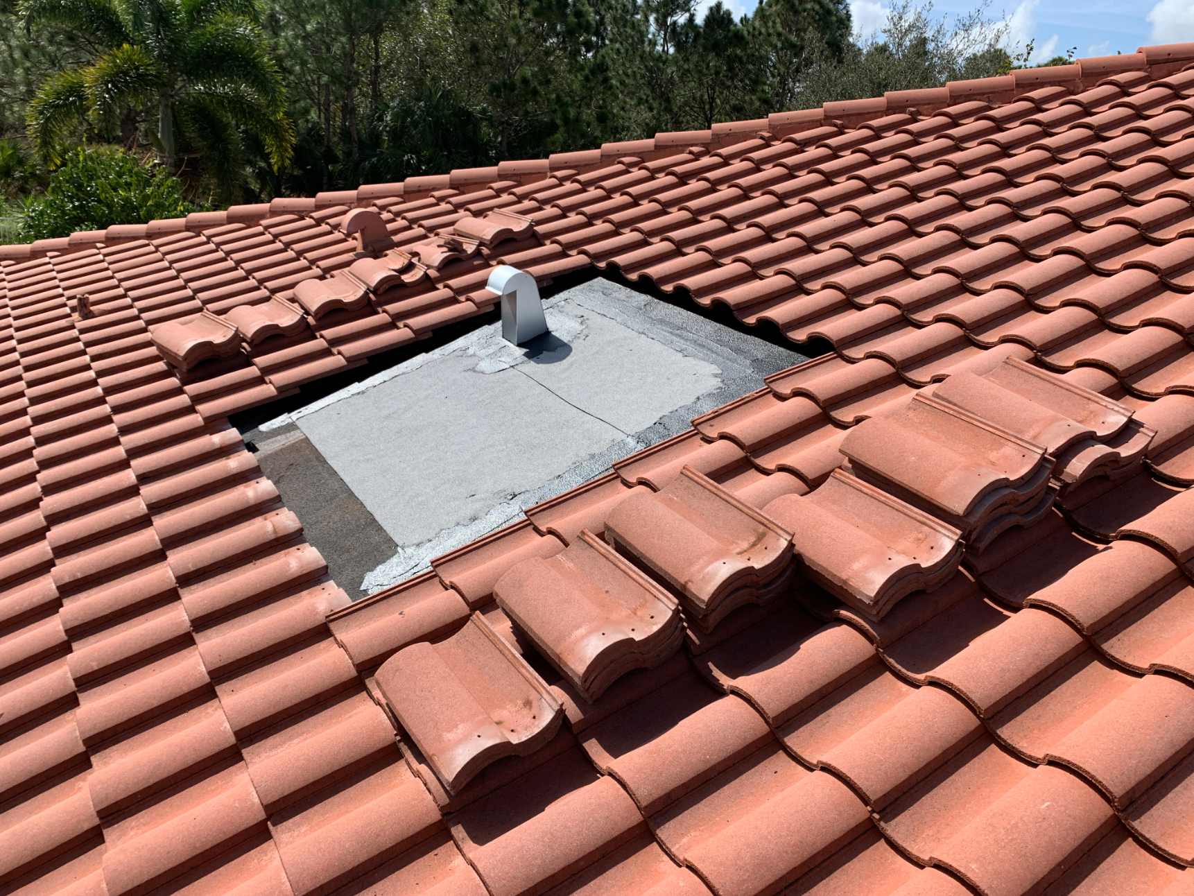 A tiled roof with a hole in the middle of it.